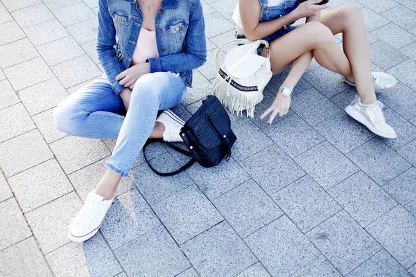 Women in jeans clothes sitting at street — Stock Photo, Image