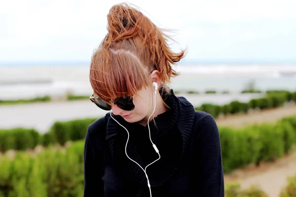 Ruiva mulher ouvindo música ao ar livre — Fotografia de Stock