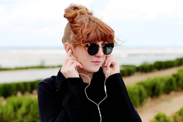 Ruiva mulher ouvindo música ao ar livre — Fotografia de Stock