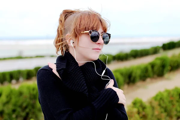 redhead woman  listening to music outdoor