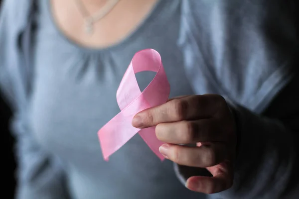 Sağlık ve tıp konsepti - kadınların elleri pembe meme kanseri farkındalığı kurdelesi tutuyor