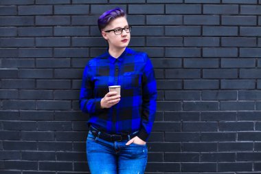Mavi Flannel Giyen Kadın Kara Duvara Karşı Kağıt Kupa Tutuyor