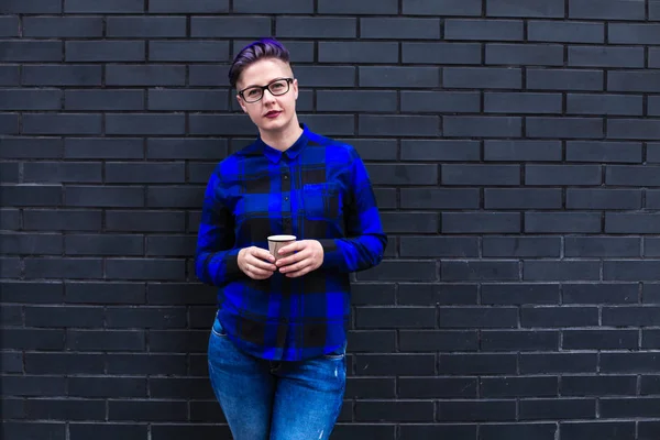 Mavi Flannel Giyen Kadın Kara Duvara Karşı Kağıt Kupa Tutuyor