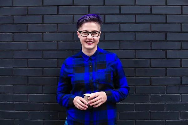 Mavi Flannel Giyen Kadın Kara Duvara Karşı Kağıt Kupa Tutuyor