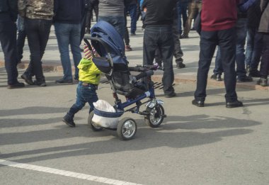 Şehir meydanındaki kalabalıkta küçük bir çocuk.