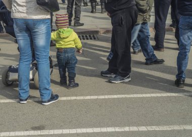 Şehir meydanındaki kalabalıkta küçük bir çocuk.
