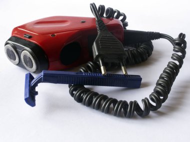 Beyaz arka planda eski bir elektrikli tıraş makinesi ve yeni bir kullan-at tıraş makinesi..