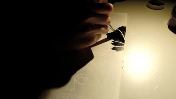 Une personne dessine de la peinture noire sur une feuille de papier — Video