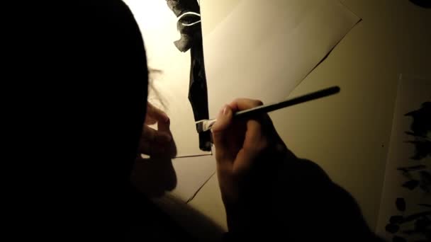 Bir insan bir kağıt parçasına siyah boya çizer. — Stok video
