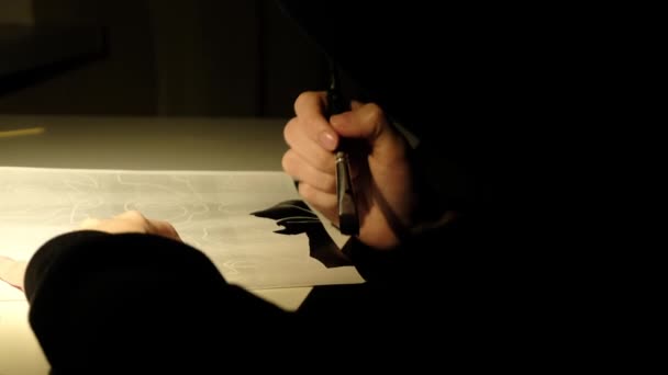 La persona dibuja pintura negra en una hoja de papel — Vídeos de Stock
