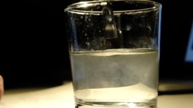 Bir insan bir kağıt parçasına siyah boya çizer.