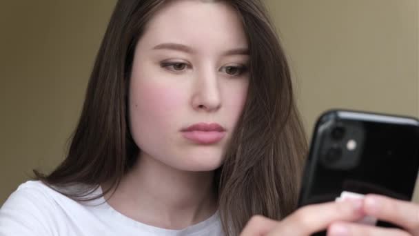 Una donna in camicia bianca e capelli neri guarda il telefono — Video Stock