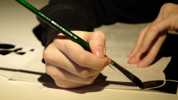 La persona dibuja pintura negra en una hoja de papel — Vídeo de stock