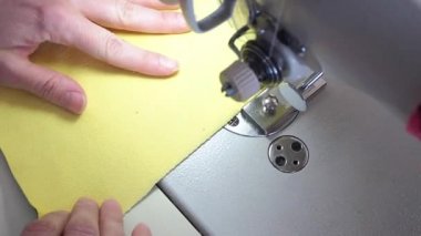 Eller bir dikiş makinesine yakın plan dikecek.