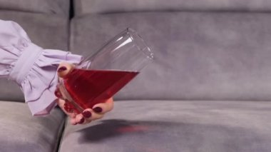 Meyve suyu bir bardaktan kanepeye dökülür.