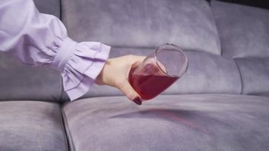 Meyve suyu bir bardaktan kanepeye dökülür.