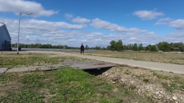 Un hombre caminando por una acera — Vídeos de Stock