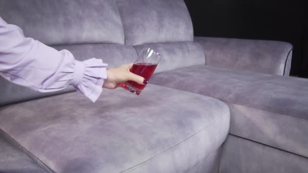 O suco vaza-se em um sofá de um copo — Vídeo de Stock