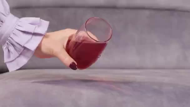 A gyümölcslevet egy pohárból öntik a kanapéra. — Stock videók