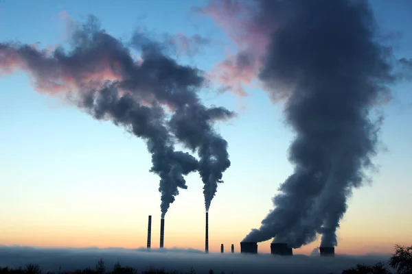 Utsläpp från kol kraftverk under solnedgången Royaltyfria Stockfoton