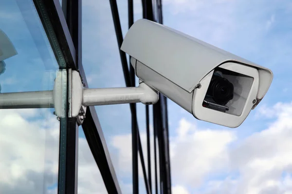 Câmera CCTV digital branca na fachada de vidro Fotos De Bancos De Imagens