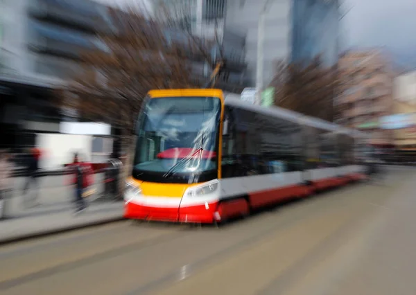 Rote moderne Straßenbahn auf der Straße in verschwommener Bewegung lizenzfreie Stockbilder