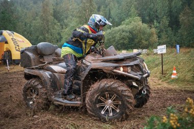 quad binici bir çamurlu orman iz üzerinde atlama.