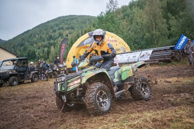 quad binici bir çamurlu orman iz üzerinde atlama.