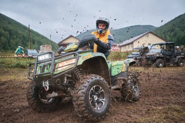 quad binici bir çamurlu orman iz üzerinde atlama.