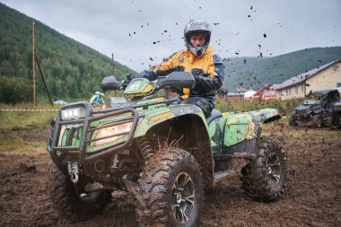 quad binici bir çamurlu orman iz üzerinde atlama.