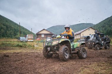 quad binici bir çamurlu orman iz üzerinde atlama.