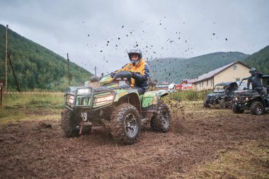 quad binici bir çamurlu orman iz üzerinde atlama.