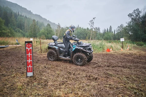 quad binici bir çamurlu orman iz üzerinde atlama.