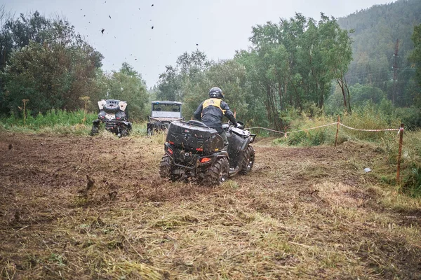 quad binici bir çamurlu orman iz üzerinde atlama.