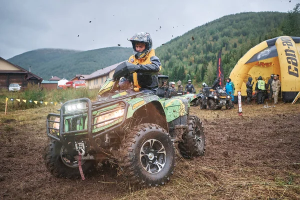 quad binici bir çamurlu orman iz üzerinde atlama.