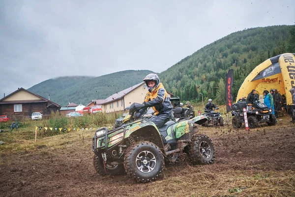 quad binici bir çamurlu orman iz üzerinde atlama.