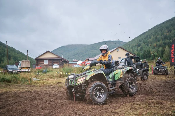 quad binici bir çamurlu orman iz üzerinde atlama.