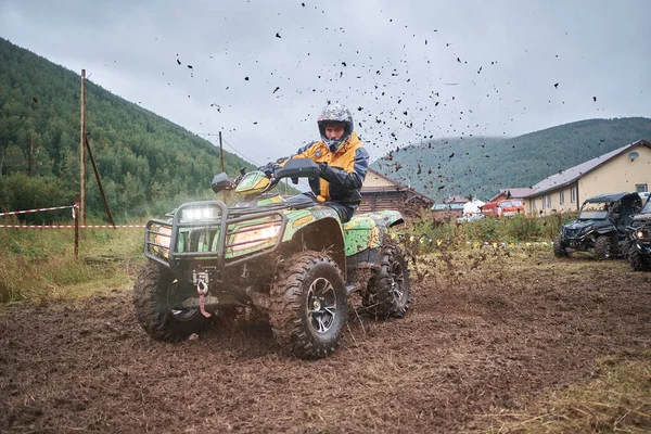 quad binici bir çamurlu orman iz üzerinde atlama.
