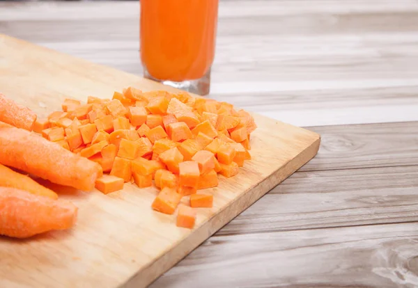 Carrots raw cut  and carrot juice on a wooden background