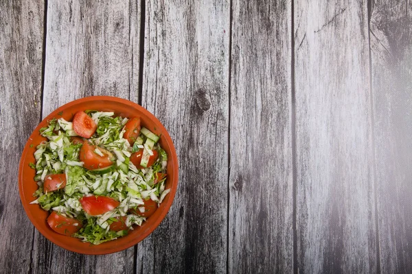 A salada fresca de tomates, pepinos e repolho está em uma ta de madeira — Fotografia de Stock