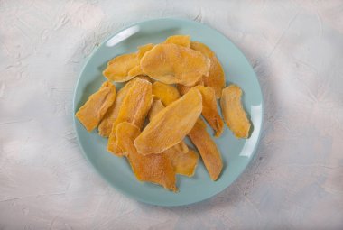 Mavi tabakta doğal mango cipsi. Düz yatıyordu