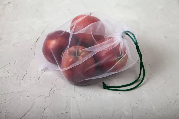 Apples, food in an eco bag on a light background. View from above. Zero waste. — 图库照片