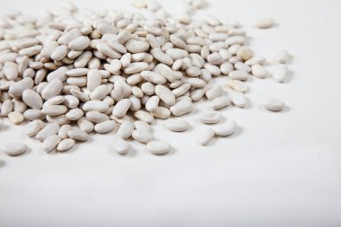 Beyaz arkaplana serpiştirilmiş taze fasulye. Kürekleri kopyala. yatay