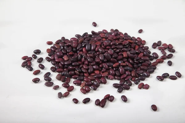 A slide of red raw beans sprinkled on a white background. Healthy lifestyle. Top view. — Stock Photo, Image