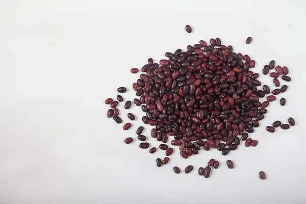 A slide of red raw beans sprinkled on a white background. Healthy lifestyle. Copy spaes — Stock Photo, Image