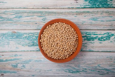 Mavi ahşap arka planda, kilden bir fincanda çiğ bezelye. Üst görünüm, metin için boşluk