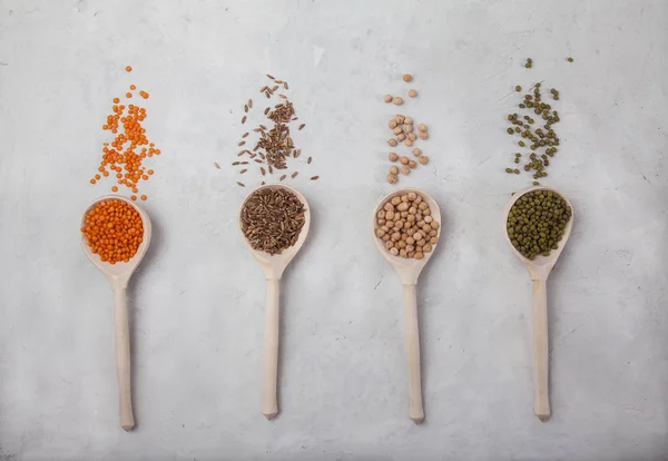 Raw red lentils, yellow peas, mung bean and wheat in wooden spoons on a white background. 수평으로 — 스톡 사진