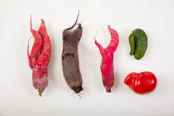 Ugly radish, beets, cucumber and promoter on a white background. Flat lay