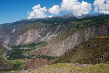 Kıvrımlı Chulyshman nehri vadisi manzarası ve yazın Altai 'deki Katu-Yaryk geçidinden gelen sarp dağ çığlıkları.