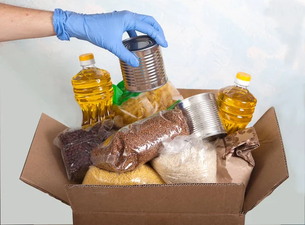 Male Hand Blue Rubber Glove Puts Can Canned Food Box — Stock Photo, Image